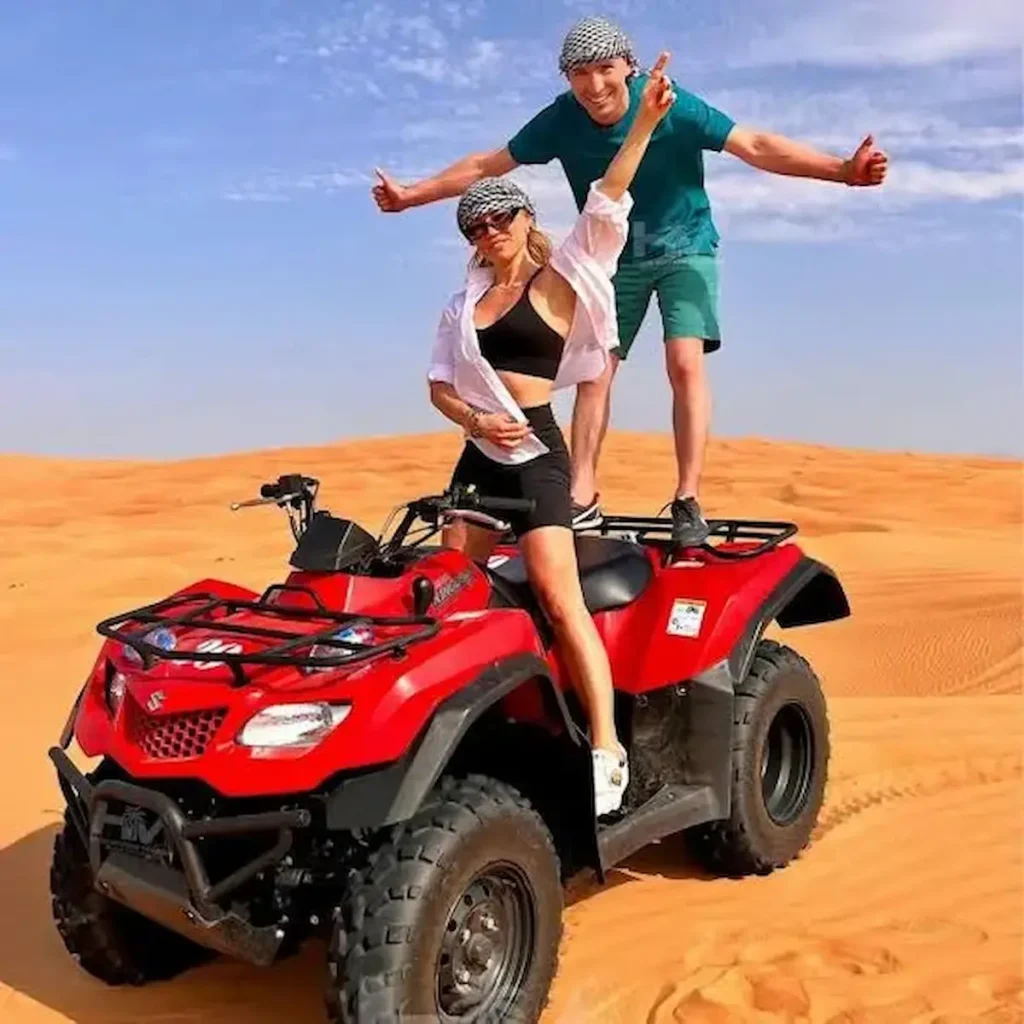 4x4 SUV dune bashing alongside an ATV quad bike during an evening desert safari in Dubai