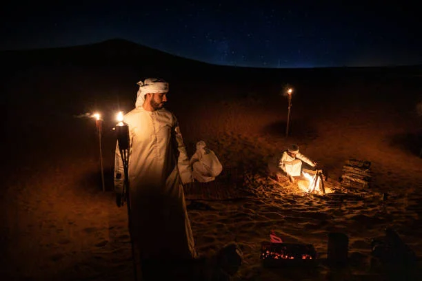 Glowing desert camp with lanterns and torches during a Dubai desert safari night adventure