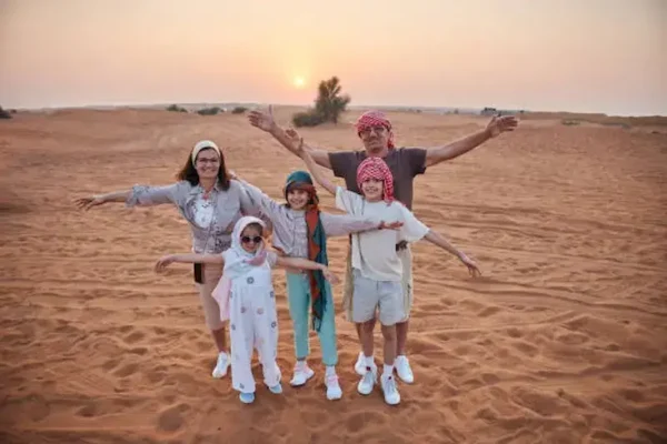Family enjoying safe dune bashing in a 4x4 during a Dubai desert safari
