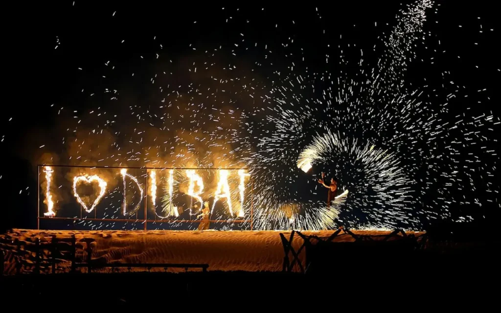 Belly dancer performing in a colorful costume at a Dubai desert safari camp at night