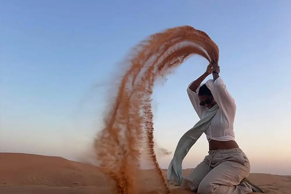 4x4 vehicle driving over sand dunes in soft early morning light during a Dubai desert safari