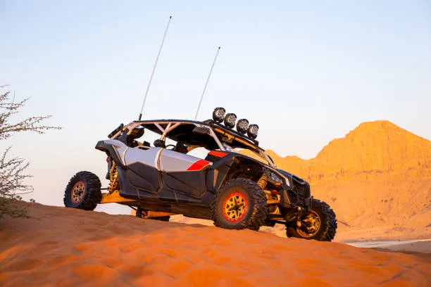Premium Can-Am Maverick dune buggy racing through sand dunes on a Dubai desert safari