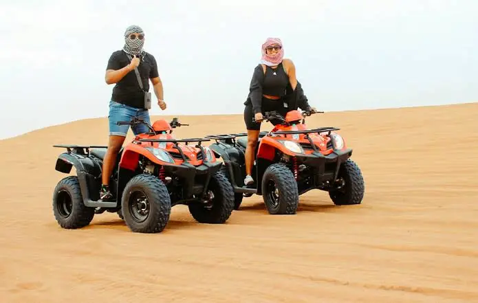 Quad bike riding over desert dunes during a morning safari